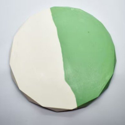 Round foam ball painted white on the left half and green on the right half. The surface appears faceted due to polygonal panels and the ball rests on a light background. - Bling On Decor® | Luxury Handmade Home Decor ANJU BALA