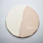 Round, faceted ceramic plate divided diagonally into white left half and pale pink right half. - Bling On Decor® | Luxury Handmade Home Decor ANJU BALA