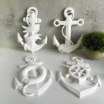 Set of white decorative nautical anchors and rope-wrapped pieces on a white table, against a gray wall with a small potted plant nearby. - Bling On Decor® | Luxury Handmade Home Decor ANJU BALA