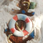Nautical-themed Christmas ornament resting on white sand with seashells scattered around it. - Bling On Decor® | Luxury Handmade Home Decor ANJU BALA