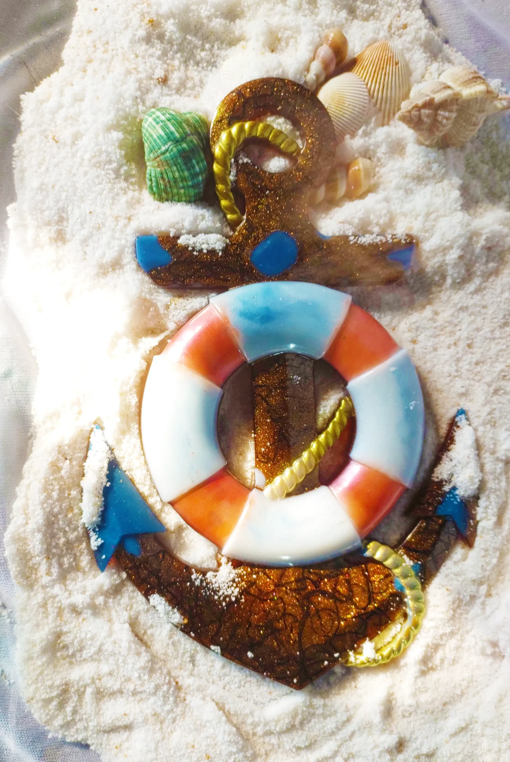 Decorative beach-themed craft on white sand featuring seashells, a glittery brown number '2' with yellow rope, and a blue-orange lifebuoy centerpiece. - Bling On Decor® | Luxury Handmade Home Decor ANJU BALA