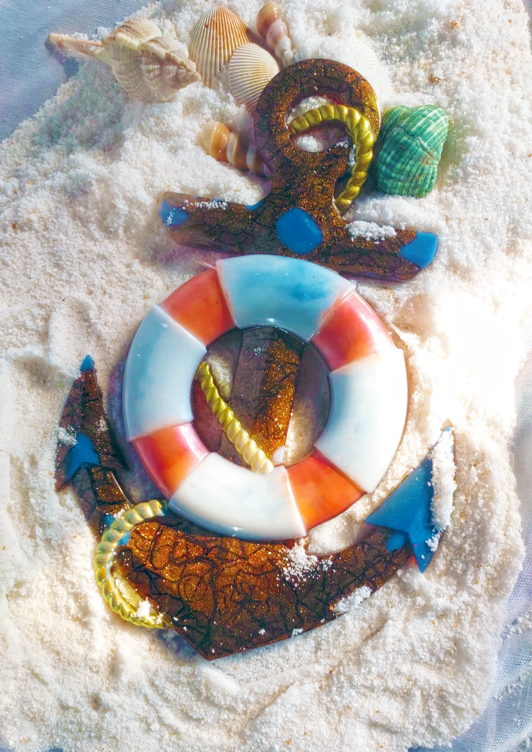 Beach-themed sugar cookies and shells arranged on white granulated sugar, including a brown textured circular life ring with blue/orange segments and a yellow rope detail. - Bling On Decor® | Luxury Handmade Home Decor ANJU BALA