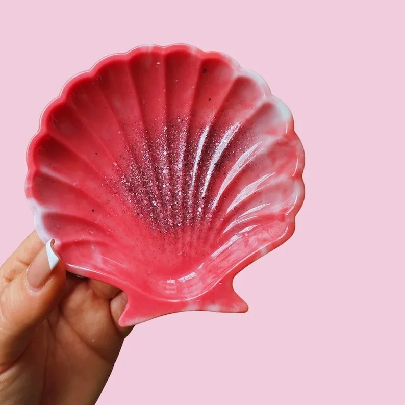 Hand holding a pink scallop-shell decorative dish with glitter against a pink background. - Bling On Decor® | Luxury Handmade Home Decor ANJU BALA