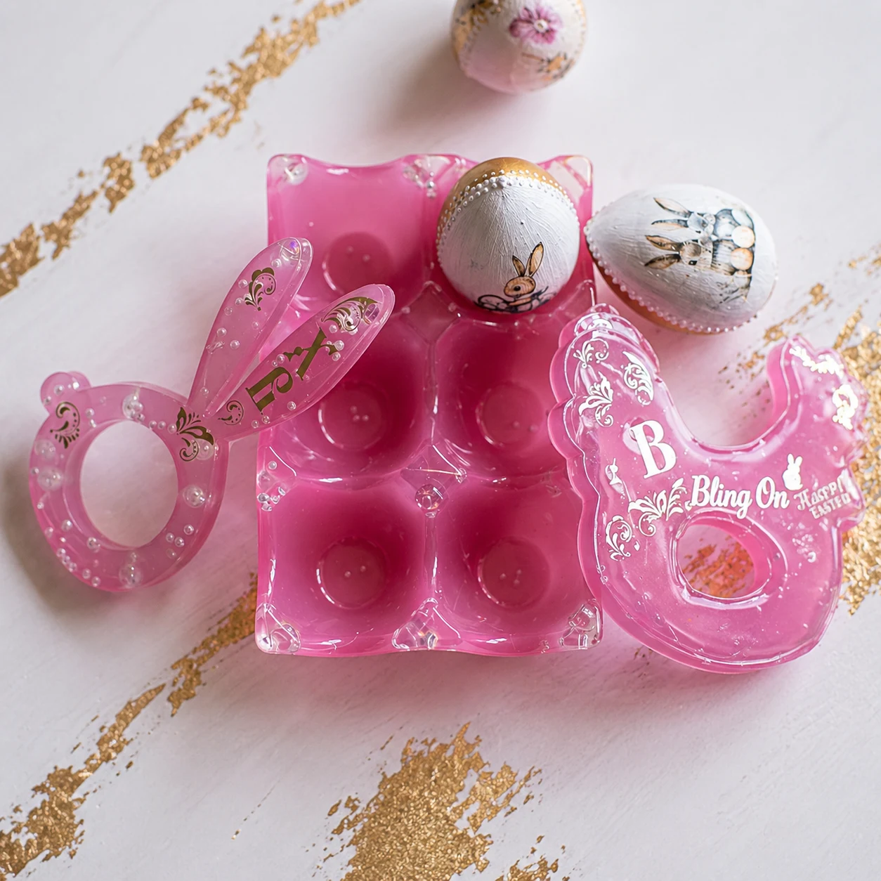 Pink Easter egg decorating kit with bunny-themed stamps and a clear mold tray on a white surface with gold confetti accents - Bling On Decor® | Luxury Handmade Home Decor ANJU BALA