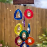 Colorful glass ring wind chime hanging from a wooden top outdoors; decorative luxury wind chime artwork - Bling On Decor® | Luxury Handmade Home Decor ANJU BALA
