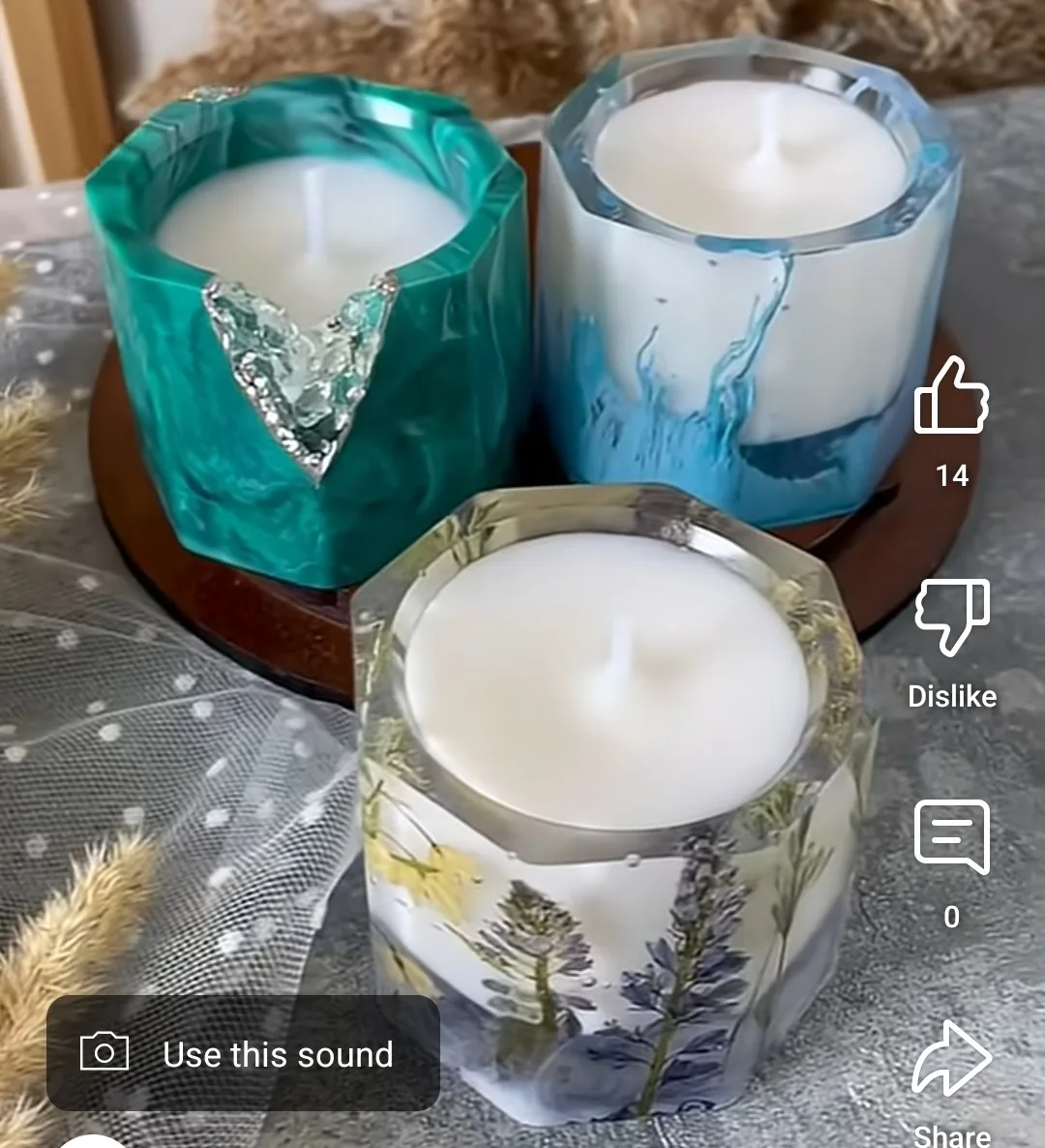 Three decorative scented candles in glass holders on a round wooden tray, set on a patterned tablecloth. - Bling On Decor® | Luxury Handmade Home Decor ANJU BALA