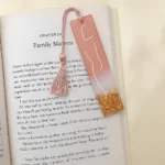 Open book page shows chapter titled 'Family Matters' with a pink bookmark tassel laid across the page and golden glitter at the bottom of the bookmark edge. - Bling On Decor® | Luxury Handmade Home Decor ANJU BALA