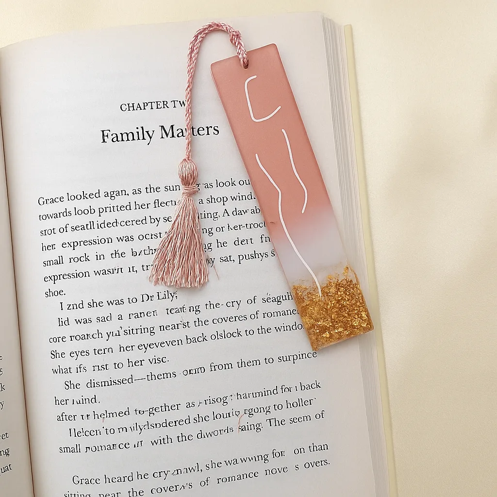 Open book page shows chapter titled 'Family Matters' with a pink bookmark tassel laid across the page and golden glitter at the bottom of the bookmark edge. - Bling On Decor® | Luxury Handmade Home Decor ANJU BALA