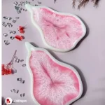 Two pink resin art pieces shaped like abstract leaves on a pale pink surface, accented with crystals and red flowers. - Bling On Decor® | Luxury Handmade Home Decor ANJU BALA
