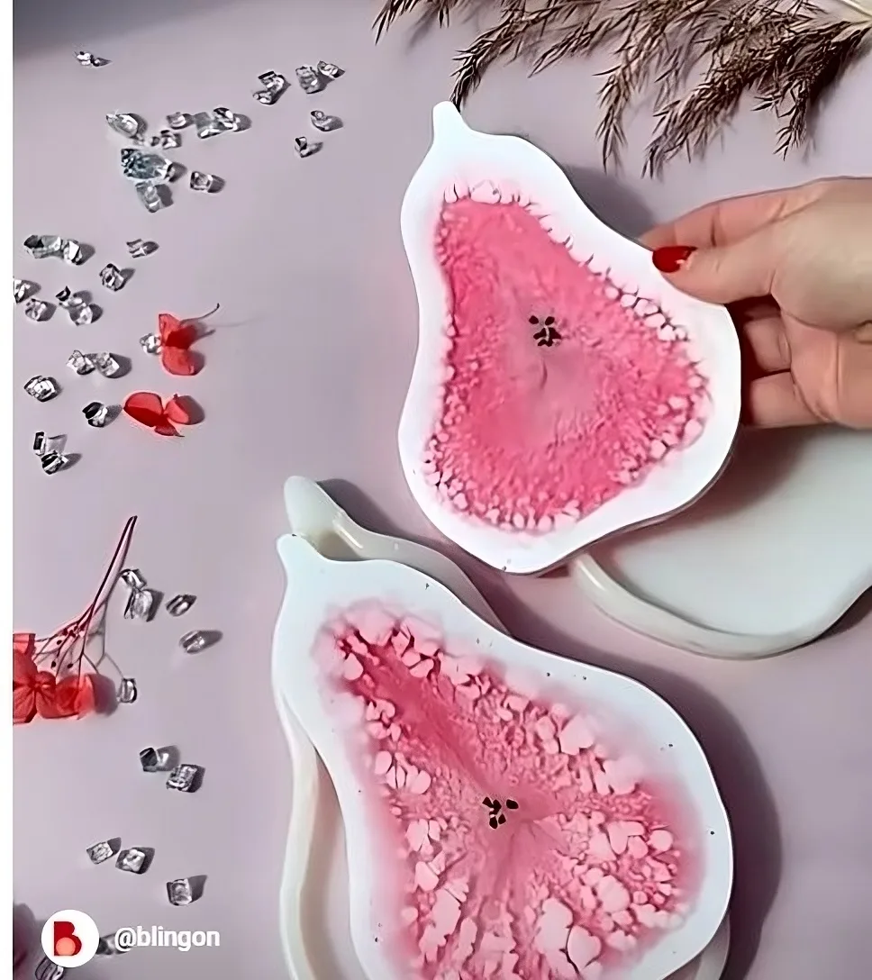 Two pink, flower-shaped silicone pads with textured centers on a light surface, with a hand holding one pad. - Bling On Decor® | Luxury Handmade Home Decor ANJU BALA