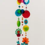 Colorful wind chime with interlocking rainbow circles, beads, and flower shapes hanging in a vertical strand. - Bling On Decor® | Luxury Handmade Home Decor ANJU BALA