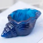 Blue glass seashell resting on a light surface, decorative ornament. - Bling On Decor® | Luxury Handmade Home Decor ANJU BALA