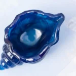Open blue glass seashell sculpture viewed from above, showing a hollow interior and spiral base with a glossy finish at the coast-tinged edge - Bling On Decor® | Luxury Handmade Home Decor ANJU BALA