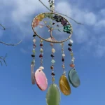 Colorful bead dreamcatcher hanging from a tree against a clear blue sky in the background. - Bling On Decor® | Luxury Handmade Home Decor ANJU BALA