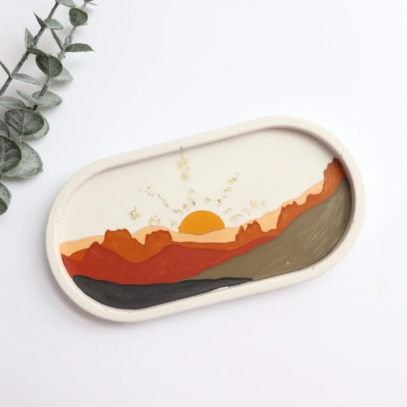 Oval ceramic tray with a hand-painted desert sunset scene, orange and red mountains under a yellow sun. - Bling On Decor® | Luxury Handmade Home Decor ANJU BALA