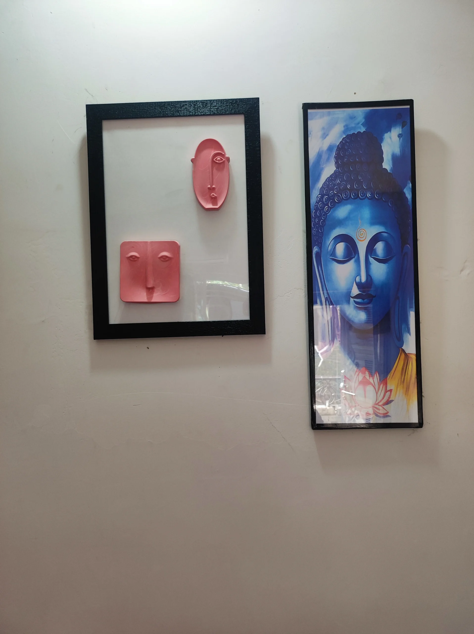 Modern-Abstract-3D-Face-Wall-Art-Frame-Handmade-Resin-Sculpture-Minimalist-Luxury-Home-Decor-by-Bling-On®-India-🇮🇳-1-scaled-1.webp - Bling On Decor® | Luxury Handmade Home Decor Left: pink abstract face sculptures mounted in a black frame on a light wall; right: tall blue Buddha poster framed in black against the wall - Bling On Decor® | Luxury Handmade Home Decor ANJU BALA