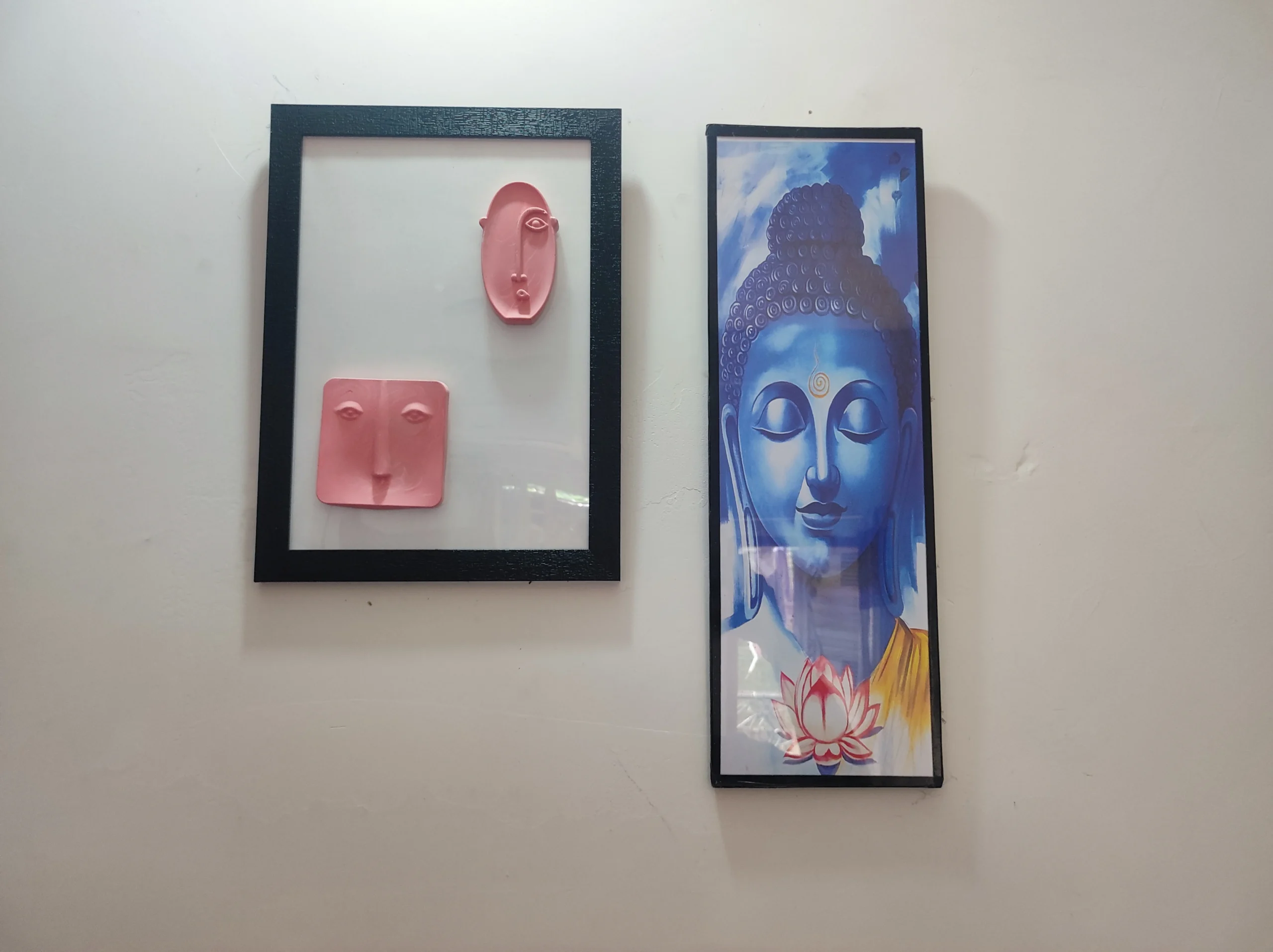 Modern-Abstract-3D-Face-Wall-Art-Frame-Handmade-Resin-Sculpture-Minimalist-Luxury-Home-Decor-by-Bling-On®-India-🇮🇳-3-scaled-1.webp - Bling On Decor® | Luxury Handmade Home Decor Two framed artworks hung side by side: a pink abstract face relief within a white background frame on the left, and a tall blue Buddha portrait within a black frame on the right. - Bling On Decor® | Luxury Handmade Home Decor ANJU BALA