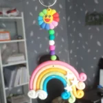 Polymer-Clay-Rainbow-Cloud-Window-Hanger-Handmade-Magic-for-Every-Space-✨-7-scaled-1.webp - Bling On Decor® | Luxury Handmade Home Decor Colorful bead wind chime with a smiling sun flower pendant hanging from a pastel rainbow arch. - Bling On Decor® | Luxury Handmade Home Decor ANJU BALA