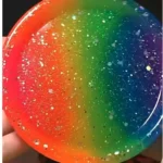 Close-up of a round, rainbow-colored bubble with glittery specks against a dark background. - Bling On Decor® | Luxury Handmade Home Decor ANJU BALA
