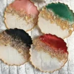 Four scalloped-edge resin coasters arranged in a 2x2 grid; top halves pink, green, black, and red with gold glitter along the bottom edge. - Bling On Decor® | Luxury Handmade Home Decor ANJU BALA