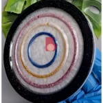 Colorful glittery circular bangles arranged in nested rings on a black plate, blue-gloved hand visible nearby. - Bling On Decor® | Luxury Handmade Home Decor ANJU BALA