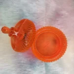 Orange glass candy dish with a fluted lid on a pastel surface. - Bling On Decor® | Luxury Handmade Home Decor ANJU BALA