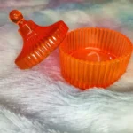 Orange ribbed glass jar with a matching domed lid on a soft pastel surface. - Bling On Decor® | Luxury Handmade Home Decor ANJU BALA