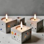 Four square terrazzo candle holders with lit tealights arranged on a surface, warm flames glowing. - Bling On Decor® | Luxury Handmade Home Decor ANJU BALA