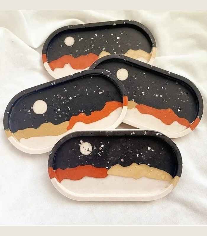 Four oval ceramic coasters with abstract desert dunes in black, orange, beige, and white. - Bling On Decor® | Luxury Handmade Home Decor ANJU BALA