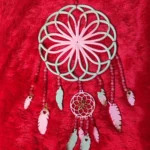 Mint green dreamcatcher pendant with petal-like spokes hanging from pink bead strands on red fuzzy background. - Bling On Decor® | Luxury Handmade Home Decor ANJU BALA