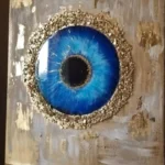 Abstract painting of a large blue eye with a gold glitter ring on a beige textured background. - Bling On Decor® | Luxury Handmade Home Decor ANJU BALA